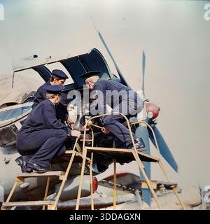Slawjansk, Ukraine, UdSSR, 1980er Jahre Kadetten der Zivilluftfahrt-Technikschule (SATU) führen während der praktischen Ausbildung Wartungsarbeiten an einem Triebwerk der Antonov an-24 durch. Drei Studenten in dunkelblauen Uniformen, von links nach rechts als S.A. Kochetygov, Yu.L. identifiziert Metik und A.I. Kochevnikov untersuchen den Propellermechanismus von einer gelben Serviceplattform aus. Die offene Verkleidung zeigt interne Komponenten. Dieses Archivbild zeigt die rigorose technische Ausbildung und Vorbereitung von Luftfahrtspezialisten in der friedlichen sowjetischen Stadt. Stockfoto