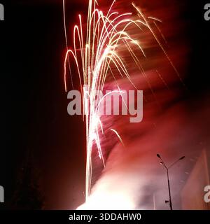 Slawjansk, Ukraine, UdSSR, 1980er Jahre Ein spektakuläres Feuerwerk (Salut), das den pechschwarzen Nachthimmel während des City Day feiert. Das mit langer Belichtung aufgenommene Foto fängt die Pyrotechnik als helle abstrakte Spuren, Funken und Lichtbögen ein. Diese Archivbilder vermitteln die festliche Atmosphäre und die visuelle Ästhetik eines sowjetischen Feiertags-Finales. Stockfoto