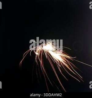 Slawjansk, Ukraine, UdSSR, 1980er Jahre Ein spektakuläres Feuerwerk (Salut), das den pechschwarzen Nachthimmel während des City Day feiert. Das mit langer Belichtung aufgenommene Foto fängt die Pyrotechnik als helle abstrakte Spuren, Funken und Lichtbögen ein. Diese Archivbilder vermitteln die festliche Atmosphäre und die visuelle Ästhetik eines sowjetischen Feiertags-Finales. Stockfoto