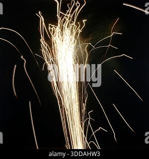 Slawjansk, Ukraine, UdSSR, 1980er Jahre Ein spektakuläres Feuerwerk (Salut), das den pechschwarzen Nachthimmel während des City Day feiert. Das mit langer Belichtung aufgenommene Foto fängt die Pyrotechnik als helle abstrakte Spuren, Funken und Lichtbögen ein. Diese Archivbilder vermitteln die festliche Atmosphäre und die visuelle Ästhetik eines sowjetischen Feiertags-Finales. Stockfoto