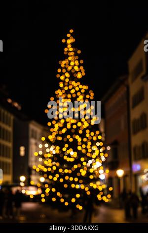 Weihnachtsbaumform mit Lichtern – absichtlich außer Fokus als Festivalhintergrund Stockfoto