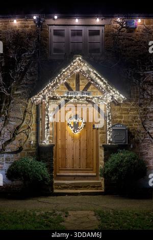 Herzform Weihnachten Deko Kranz mit Lichtern auf die Eingangstür eines Cottage in Deddington, Oxfordshire, England Stockfoto