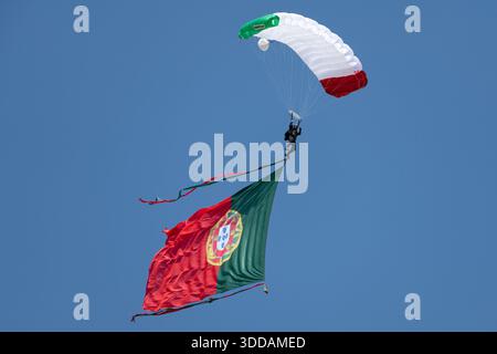 Beja, Portugal - 18. Juni 23: Fallschirmspringer mit portugiesischer Flagge gegen klaren blauen Himmel Stockfoto