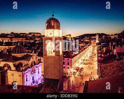 Aus der Vogelperspektive auf den beleuchteten Glockenturm und die Stradun Straße, die Hauptdurchgangsstraße, die ein warmes Licht gegen die sich vertiefende Dämmerung ausstrahlt, Dubrovnik, du Stockfoto