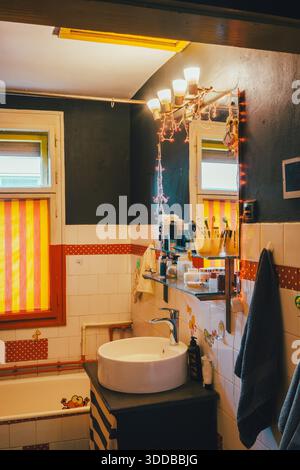 Das Innere des alten Badezimmers ist mit großem, modernem Waschbecken und Spiegel ausgestattet. Stockfoto