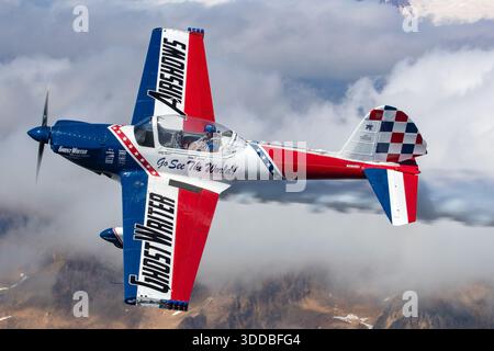 Air-to-Air-Foto, das das Ghostwriter Super Chipmunk-Flugzeug, ein modifiziertes de Havilland Chipmunk, während einer Skywriting-Demonstration auf der Abbotsford International Airshow in Kanada 2025 zeigt. Das Bild zeigt eine Nahaufnahme des Piloten, der im Cockpit sitzt, während sich das Flugzeug im Flug befindet. Das Flugzeug trägt die US-Zulassungsnummer N260DC und wird im Rahmen einer offiziellen Flugschau bei kontrollierten Luftoperationen erfasst. Stockfoto