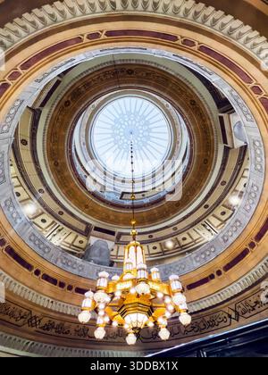 Mekka, Saudi-Arabien – 18. Dezember 2025: Goldener Kronleuchter hängt im Masjid al-Haram und hebt die islamische Innenbeleuchtung hervor. Stockfoto