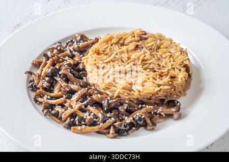 Das gemütliche Reisgericht besteht aus Butterpilzen, Sesamgarnitur und perfekt gekochtem Reis Stockfoto