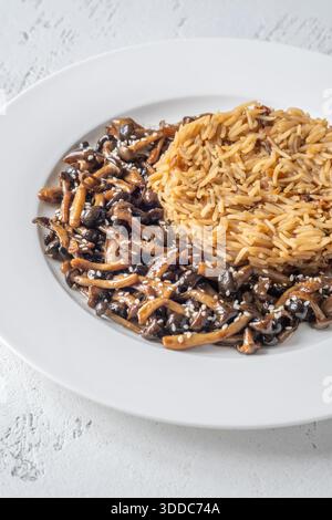 Das gemütliche Reisgericht besteht aus Butterpilzen, Sesamgarnitur und perfekt gekochtem Eigelb Stockfoto