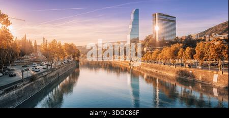 31. Oktober 2025, Tiflis, Georgien: Tbilisss Stadtbild, das den Fluss Kura, moderne Architektur und herbstliche Bäume bei einem wunderschönen Sonnenaufgang einfängt Stockfoto