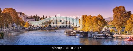 31. Oktober 2025, Tiflis, Georgien: Panorama mit Friedensbrücke und Fluss Kura, mit Herbstbäumen und Stadtarchitektur Stockfoto