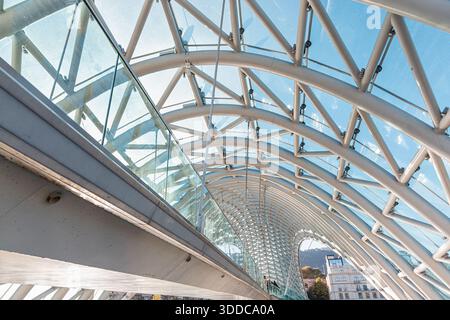 31. Oktober 2025, Tiflis, Georgien: Friedensbrücke mit modernem Fachwerkbau mit Glaspaneelen Stockfoto