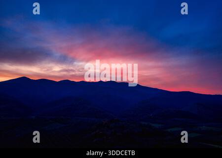 Kerkini, Nordgriechenland – leuchtende Farben bei Sonnenuntergang umrahmen die Silhouetten der Berge und erfassen die natürliche Schönheit, Gelassenheit und stimmungsvolle Tiefe Stockfoto