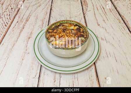 Klassische Wonton-Suppe mit Schweinefleisch und Garnelen, serviert in aromatischer Hühnerbrühe mit Pak Choy und frisch geschnittenen Zwiebeln Stockfoto