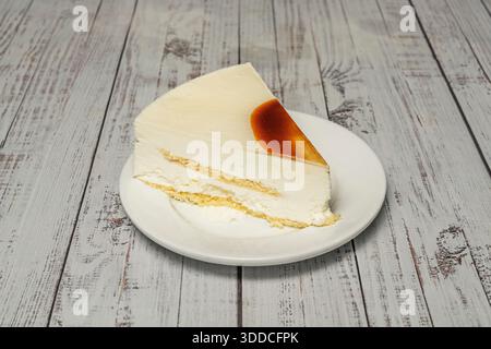 Gebackener Käsekuchen mit Zimt- und graham-Cracker-Kruste, serviert mit Dulce de leche-Sauce und Dulce de leche-Eis, eine klassische Präsentation Stockfoto