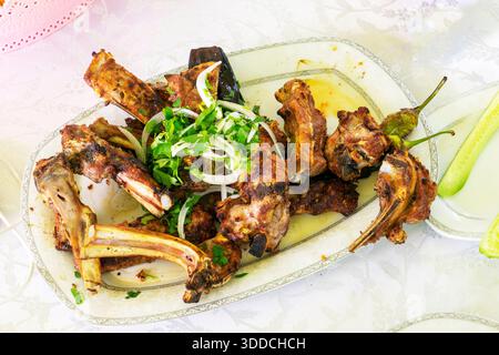 Verschiedene Shish Kebabs, Gemüse, Salat mit frischen Tomaten und Gurken auf dem Tisch, nationale, östliche Gerichte. Stockfoto