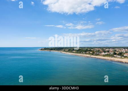 Aus der Vogelperspektive auf eine sanft geschwungene Küste mit türkisfarbenem Atlantikwasser, das auf ein Sandufer und eine Ansammlung von weißen Häusern auf der Ile de Re, Charente-Maritime, trifft. Schwammige Wolken ziehen über einen breiten blauen Himmel und schaffen eine geräumige und ruhige Atmosphäre am Meer. Stockfoto