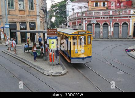 RIO DE JANEIRO, BRASILIEN - 10. MAI 2016: Santa Teresa Tramway Oldtimer Yellow Kutsche hält an der Endstation Largo dos Guimaraes und Passanten W Stockfoto