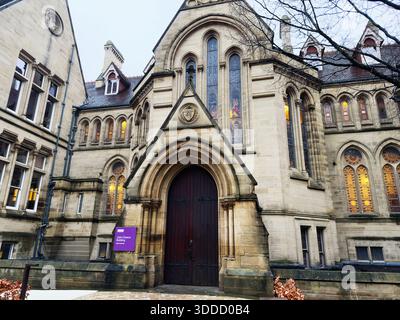 Manchester, Großbritannien - 06. Dezember 2025: Das gotische John Owens Campus-Gebäude in Manchester verfügt über eine bogenförmige Eingangstür, Buntglas und eine warme Inneneinrichtung Stockfoto