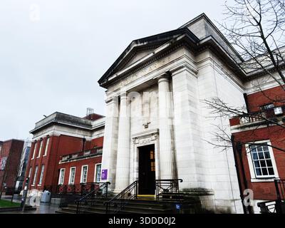 Manchester, Großbritannien - 06. Dezember 2025: Neoklassizistischer Eingang zur Manchester Faculty of Arts mit hohen Säulen und Treppen auf dem Campus. Stockfoto