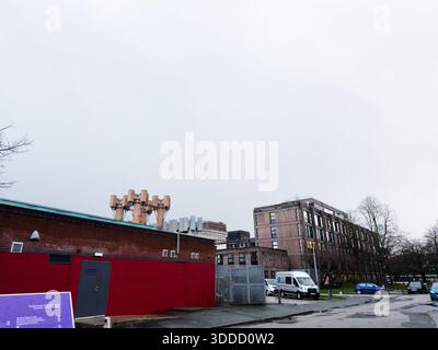 Manchester, Großbritannien - 06. Dezember 2025: Bewölktes Stadtbild in Manchester mit Industriemauern, Minibus und ruhiger urbaner Umgebung. Stockfoto