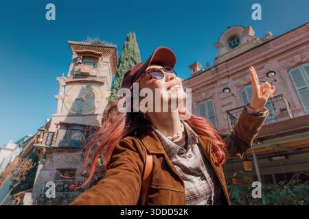 3. November 2025, Tiflis, Georgien: Junge Frau lächelt, blickt auf den berühmten Glockenturm des Gabriadze-Theaters in der Altstadt Stockfoto