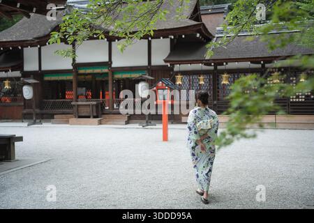 Frau mit Yukata, die vor den historischen Holzgebäuden des Kawai-Schreins steht. Kyoto, Japan. Stockfoto