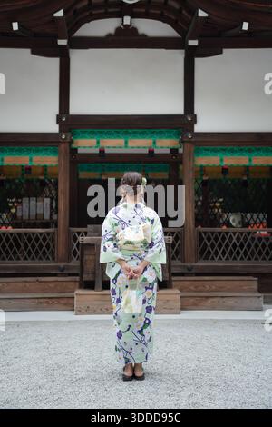 Frau mit Yukata, die vor den historischen Holzgebäuden des Kawai-Schreins steht. Kyoto, Japan. Stockfoto