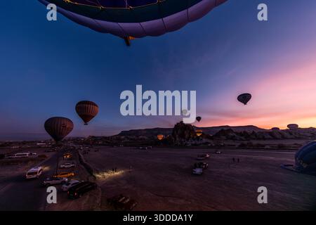 Heißluftballons starten in der Nähe von Göreme in Kappadokien vor Sonnenaufgang. Zentralanatolien, Türkei Stockfoto