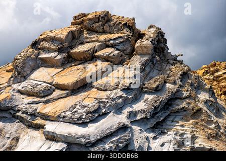 Dramatische Landschaft aus Klippen Felsen Steinstruktur Nahaufnahme am Strand der Insel Ikaria in Griechenland im Sommer mit Blick auf die Natur von Karkinagri Stockfoto