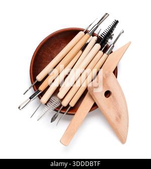 Keramikplatte mit Satz von Bildhauerwerkzeugen isoliert auf weißem Hintergrund Stockfoto
