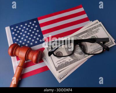 Holzgabel, US-Dollar-Scheine und eine Brille auf einer amerikanischen Flagge. Stockfoto