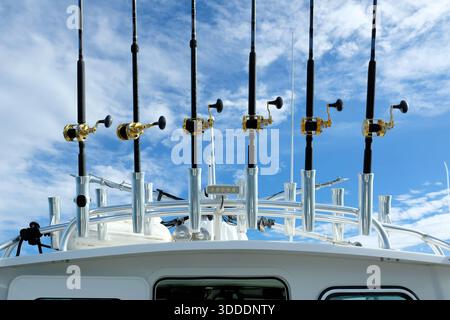 Meeresfischstangen auf einem Edelstahl-Boot-Dachgestell; Ruten und Rollen für Sportfischerei vor blauem Himmel mit trüben Wolken; Kalifornien. Stockfoto