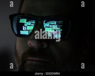 Man Hacking at Terminal Command Prompt Ausführen von Netzwerken Scans und Paketaufzeichnungen – Reflexion in Brille Black hat Concept Stockfoto