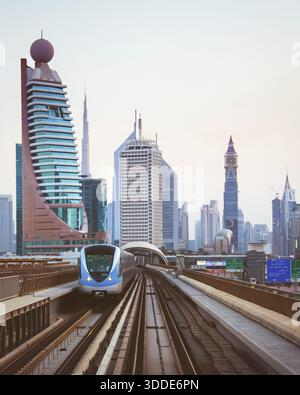 Dubai, VAE - 10. oktober 2022: Fahrerloser Dubai Metro-Zug, der auf erhöhten Gleisen auf der Sheikh Zayed Road mit der Stadt skylineâ€”einschließlich BU fährt Stockfoto