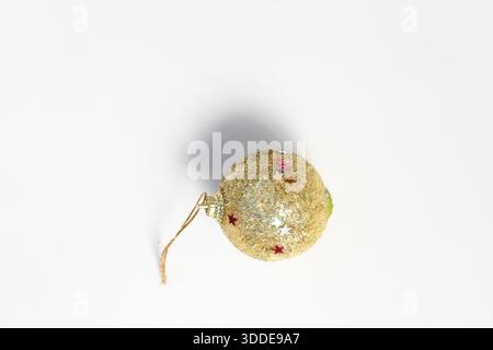 Goldene Glitzerkugel mit roten Akzenten. Weihnachtsdekoration isoliert auf weiß Stockfoto
