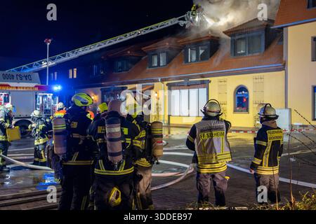 Lieferwagen brennt neben Gebäude Feuer greift auf Dachstuhl über am 31.12.2025 geriet kurz vor 02:00 Uhr ein Lieferwagen in Brand, der direkt neben einem Gebäude mit Wohn- und Geschäftseinheiten in Bickenbach Stand. Die Flammen griffen auf den angrenzenden Dachstuhl über und breiteten sich auf dem Großteil des Dachbodens aus. Da dieser nicht von innen erreichbar war, müssen die Einsatzkräfte die gesamten Dachziegel entfernen, um gezielte Löschmaßnahmen durchführen zu können. Vier Drehleitern sowie ein Mast der Werkfeuerwehr Merck kam zum Einsatz. Winterliche Minusgrade erschwerten die Lösc Stockfoto
