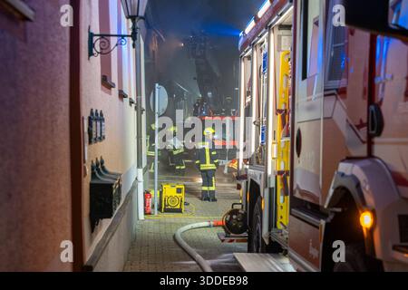 Lieferwagen brennt neben Gebäude Feuer greift auf Dachstuhl über am 31.12.2025 geriet kurz vor 02:00 Uhr ein Lieferwagen in Brand, der direkt neben einem Gebäude mit Wohn- und Geschäftseinheiten in Bickenbach Stand. Die Flammen griffen auf den angrenzenden Dachstuhl über und breiteten sich auf dem Großteil des Dachbodens aus. Da dieser nicht von innen erreichbar war, müssen die Einsatzkräfte die gesamten Dachziegel entfernen, um gezielte Löschmaßnahmen durchführen zu können. Vier Drehleitern sowie ein Mast der Werkfeuerwehr Merck kam zum Einsatz. Winterliche Minusgrade erschwerten die Lösc Stockfoto