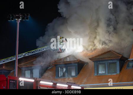 Lieferwagen brennt neben Gebäude Feuer greift auf Dachstuhl über am 31.12.2025 geriet kurz vor 02:00 Uhr ein Lieferwagen in Brand, der direkt neben einem Gebäude mit Wohn- und Geschäftseinheiten in Bickenbach Stand. Die Flammen griffen auf den angrenzenden Dachstuhl über und breiteten sich auf dem Großteil des Dachbodens aus. Da dieser nicht von innen erreichbar war, müssen die Einsatzkräfte die gesamten Dachziegel entfernen, um gezielte Löschmaßnahmen durchführen zu können. Vier Drehleitern sowie ein Mast der Werkfeuerwehr Merck kam zum Einsatz. Winterliche Minusgrade erschwerten die Lösc Stockfoto