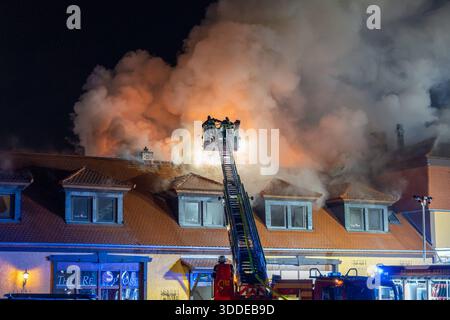 Lieferwagen brennt neben Gebäude Feuer greift auf Dachstuhl über am 31.12.2025 geriet kurz vor 02:00 Uhr ein Lieferwagen in Brand, der direkt neben einem Gebäude mit Wohn- und Geschäftseinheiten in Bickenbach Stand. Die Flammen griffen auf den angrenzenden Dachstuhl über und breiteten sich auf dem Großteil des Dachbodens aus. Da dieser nicht von innen erreichbar war, müssen die Einsatzkräfte die gesamten Dachziegel entfernen, um gezielte Löschmaßnahmen durchführen zu können. Vier Drehleitern sowie ein Mast der Werkfeuerwehr Merck kam zum Einsatz. Winterliche Minusgrade erschwerten die Lösc Stockfoto