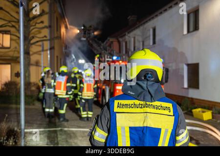 Lieferwagen brennt neben Gebäude Feuer greift auf Dachstuhl über am 31.12.2025 geriet kurz vor 02:00 Uhr ein Lieferwagen in Brand, der direkt neben einem Gebäude mit Wohn- und Geschäftseinheiten in Bickenbach Stand. Die Flammen griffen auf den angrenzenden Dachstuhl über und breiteten sich auf dem Großteil des Dachbodens aus. Da dieser nicht von innen erreichbar war, müssen die Einsatzkräfte die gesamten Dachziegel entfernen, um gezielte Löschmaßnahmen durchführen zu können. Vier Drehleitern sowie ein Mast der Werkfeuerwehr Merck kam zum Einsatz. Winterliche Minusgrade erschwerten die Lösc Stockfoto