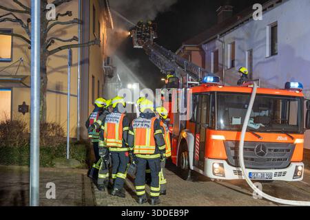 Lieferwagen brennt neben Gebäude Feuer greift auf Dachstuhl über am 31.12.2025 geriet kurz vor 02:00 Uhr ein Lieferwagen in Brand, der direkt neben einem Gebäude mit Wohn- und Geschäftseinheiten in Bickenbach Stand. Die Flammen griffen auf den angrenzenden Dachstuhl über und breiteten sich auf dem Großteil des Dachbodens aus. Da dieser nicht von innen erreichbar war, müssen die Einsatzkräfte die gesamten Dachziegel entfernen, um gezielte Löschmaßnahmen durchführen zu können. Vier Drehleitern sowie ein Mast der Werkfeuerwehr Merck kam zum Einsatz. Winterliche Minusgrade erschwerten die Lösc Stockfoto