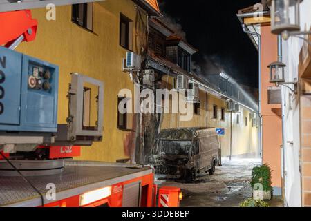 Lieferwagen brennt neben Gebäude Feuer greift auf Dachstuhl über am 31.12.2025 geriet kurz vor 02:00 Uhr ein Lieferwagen in Brand, der direkt neben einem Gebäude mit Wohn- und Geschäftseinheiten in Bickenbach Stand. Die Flammen griffen auf den angrenzenden Dachstuhl über und breiteten sich auf dem Großteil des Dachbodens aus. Da dieser nicht von innen erreichbar war, müssen die Einsatzkräfte die gesamten Dachziegel entfernen, um gezielte Löschmaßnahmen durchführen zu können. Vier Drehleitern sowie ein Mast der Werkfeuerwehr Merck kam zum Einsatz. Winterliche Minusgrade erschwerten die Lösc Stockfoto