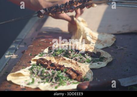 Traditioneller türkischer Leberkebab auf Lavash-Fladenbrot mit frischer Petersilie und Zwiebelsalat Stockfoto