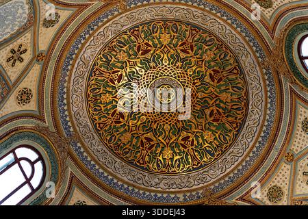 Arabesken-Ornament an der Decke, Istanbul, Türkei, dekoratives architektonisches Detail aus dem Topkapı-Palast, das ein kompliziertes konzentrisches mandala-ähnliches Muster aus verschachtelten goldenen Arabesken und stilisierten Blumenmotiven in Grün, Blau, Rot und Gold auf einer gewölbten Holzoberfläche zeigt. Topkapı-Palast-Museum, Istanbul. Quelle: Topkapı Palace Museum, Istanbul / AF Fotografie Stockfoto