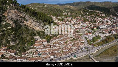 Aus der Vogelperspektive von Berat mit Häusern am Hügel unter dem felsigen Hang, der zur Burg und zum Fluss Osum führt. Stockfoto