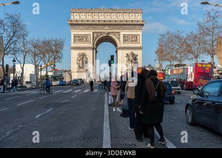 Touristen stehen mitten in der Avenue des Champs-Elysées, um Fotos vom Arc de Triomph im 8. Arrondissement von Paris zu machen Stockfoto