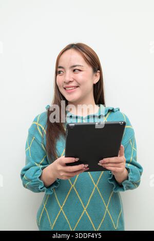 Studio-Porträt einer jungen asiatischen Frau vor weißem Hintergrund mit Tablet-Computer Stockfoto