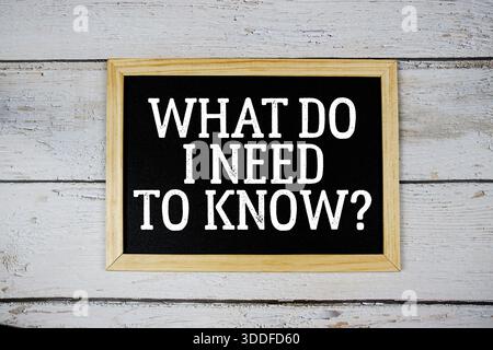 Was muss ich wissen? Text mit Tafel auf hölzernem Hintergrund Stockfoto