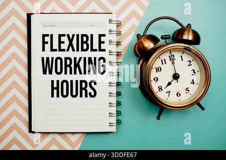 Text für flexible Arbeitszeiten auf Notizblock mit Wecker geschrieben Stockfoto